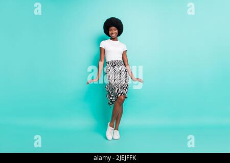 Photo of flirty shy dark skin lady wear casual clothes walking smiling isolated teal color background Stock Photo