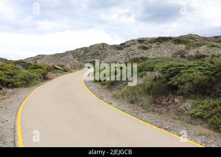 Curvy Road with yellow lines going up the mountains in Spain Stock Photo