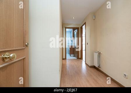 Narrow hallway of a house with a wall covered with mirrors framed in squares Stock Photo