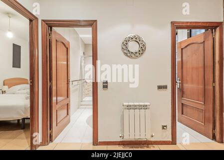 Distributor of a residential house with access to several rooms and a bathroom with wooden doors in a reddish or mahogany tone Stock Photo