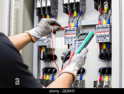 Engineering inspecting the operation of electrical control equipment. Stock Photo