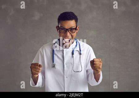 Young emotional african american doctor clenched his fists and shouted hurray. Stock Photo