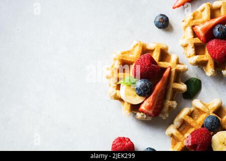 Belgian waffles with berries on a gray background. Top view and copy space. Stock Photo