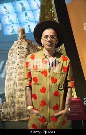 EMBARGOED UNTIL 12.01am 28 JUNE 2022 London, UK, 27 June 2022: The V&A Museum opens it's newest exhibit, 'Africa Fashion', the UK's most extensive exhibition of African fashions to date with over 250 objects on display. Moroccan designer Artsi Ifrach of Maison Artc, poses with a dress and mask of his own design. Anna Watson/Alamy Live News Stock Photo