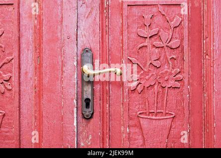 an old red door with ornamental carvings Stock Photo