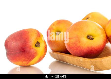 Several juicy organic nectarines on a wooden tray, close-up, isolated on a white background. Stock Photo