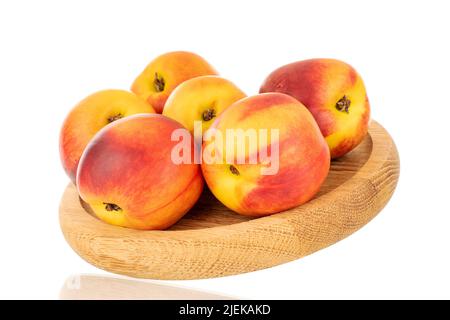 Several juicy organic nectarines on a wooden tray, close-up, isolated on a white background. Stock Photo