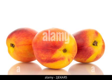 Three juicy organic nectarines, close-up, isolated on white background. Stock Photo
