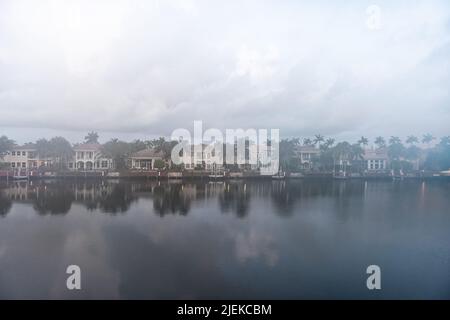 Cloudy foggy mist morning in Hollywood Beach in Miami, Florida Stranahan river and view of waterfront villas houses with palm trees and calm water ref Stock Photo