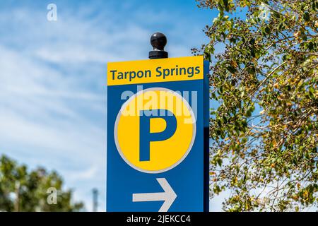 Tarpon Springs, Florida Greek town sign on road street for parking lot closeup with blue sky background and yellow colors Stock Photo