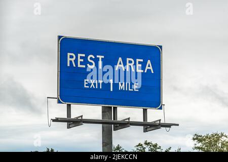 Blue color sign isolated closeup for rest area stop right exit in one mile in Sparks, south Georgia on interstate highway 75 with cloudy sky in backgr Stock Photo
