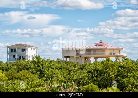 Colorful stilted vacation oceanfront waterfront homes houses on stilts of Atlantic ocean beach by mangrove forest in summer of Palm Coast on Crescent Stock Photo
