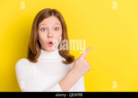 Photo of young girl amazed shocked surprised point finger empty space advert isolated over yellow color background Stock Photo