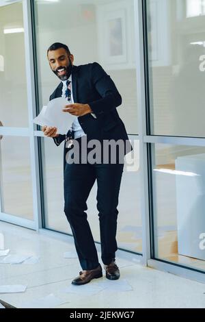 Business stress overwhelmed African American businessman throwing papers in the air office shot Stock Photo