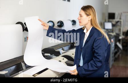 Woman working in printing office, using printer Stock Photo