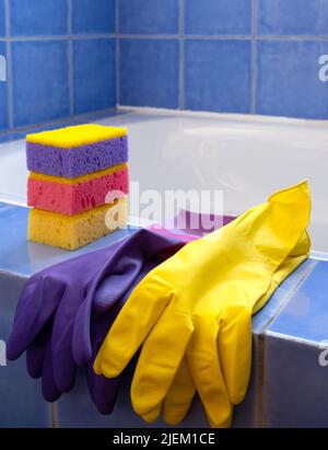 Rubber gloves and sponges on the bathroom. Closeup. Set of colorful accessory for house cleaning. Clean house. Front view. Stock Photo