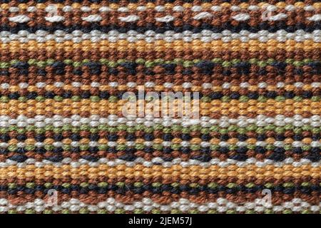 Plain weave fabric macro texture. Cloth background with horizontal strips of white, yellow, green, brown and black colors. Colorful textile surface. Stock Photo