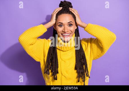 Photo portrait of impressed woman holding head with two hands isolated on vivid violet colored background Stock Photo
