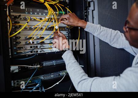 Close up of IT engineer connecting cables in server room while setting up data network, copy space Stock Photo