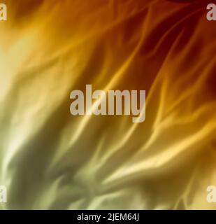 Yellow satin fabric textures. Velvet smooth material with elegant folds. Shiny hues of gold and orange in luxury cloth or wavy designs. Abstract Stock Photo