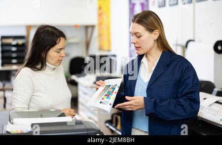 Women publishing facility workers having conversation about work Stock Photo
