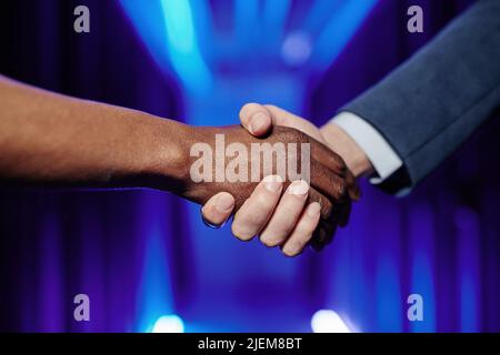 Close up of employer shaking hands with worker in data center interior Stock Photo