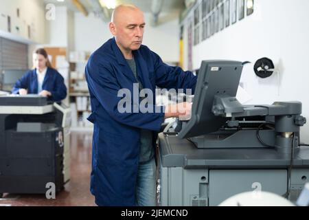 Man working in publishing facility Stock Photo