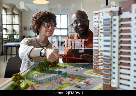 Two architects discussing construction mock-up of building together during teamwork at office Stock Photo