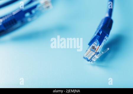 Blue Ethernet Cable Connectors Patch cord cord close-up isolated on a blue background with free space Stock Photo