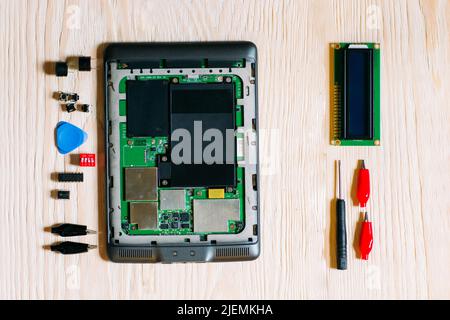 Disassembles tablet on wooden background Stock Photo