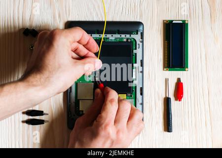 Technician repair tablet on wooden background Stock Photo