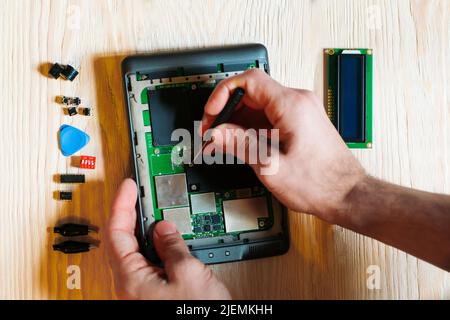 Technician repair tablet on wooden background Stock Photo