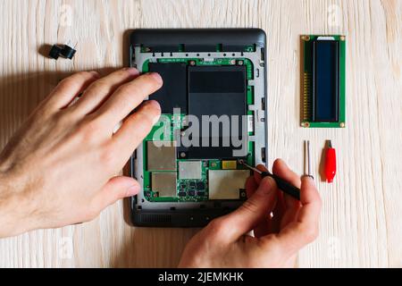 Technician repair tablet on wooden background Stock Photo