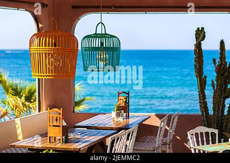 Eating concept with beautiful greek restaurant tables by the sea Stock Photo
