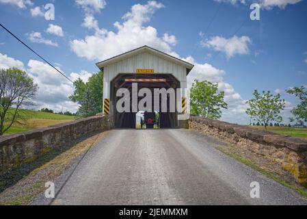 Amish horse and buggy crossing Weaver's Mill covered bridge in Lancaster County, Pennsylvania Stock Photo