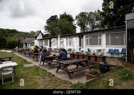 Spectators at Armitage Bridge Cricket Club in Huddersfield, Yorkshire watching a club game in progress and enjoying refreshments, food and facilities Stock Photo