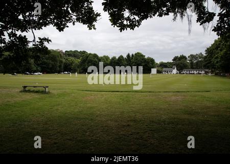 View of an English Club cricket match in progress set in a natural amphitheatre surrounded by trees in Huddersfield, West Yorkshire, England Stock Photo