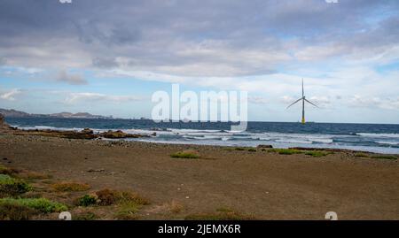 February 03 2022.A giant eolian wind turbine producing green energy in the Atlantic Ocean near the western coast of Gran Canaria.In the background are Stock Photo