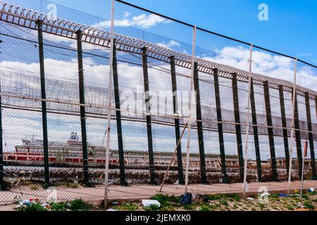 Fence that separates the city of Melilla from the Moroccan port of Nador. The Melilla border fence forms part of the Morocco–Spain border in the city Stock Photo