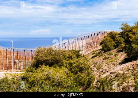 The Melilla border fence forms part of the Morocco–Spain border in the city of Melilla. Constructed by Spain, its stated purpose is to stop illegal im Stock Photo