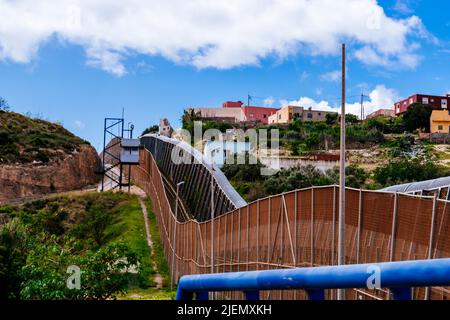 The Melilla border fence forms part of the Morocco–Spain border in the city of Melilla. Constructed by Spain, its stated purpose is to stop illegal im Stock Photo