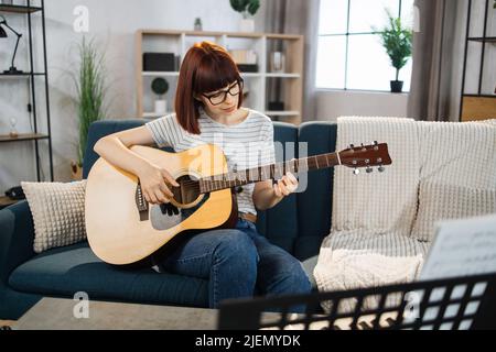 A music teacher conducts a lesson on playing a musical instrument over the Internet. Guitar lessons online and online music training during quarantine for the coronavirus pandemic. Stock Photo