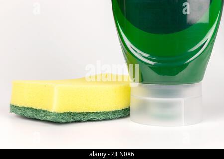 Dishwashing green liquid with a sponge in an upside down bottle front view Stock Photo