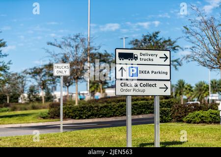 Jacksonville, USA - October 19, 2021: Sign for IKEA home furnishings furniture warehouse center store parking and delivery trucks with click and colle Stock Photo