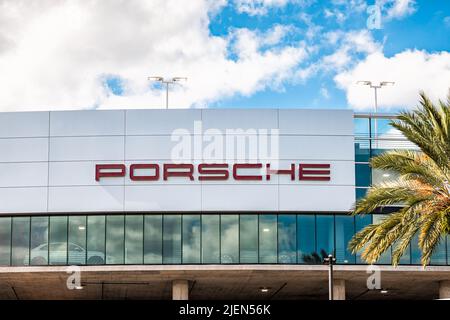 Orlando, USA - October 19, 2021: Porsche brand car auto dealer dealership building facade sign with indoor parking lot for cars in Florida selling new Stock Photo