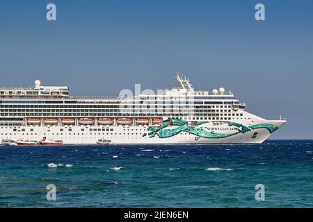 Mykonos, Greece - June 2022: Side view of the front of the Norwegian Jade cruise ship anchored at sea off the Greek Island. Stock Photo