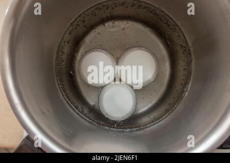 boiling eggs in saucepan Stock Photo