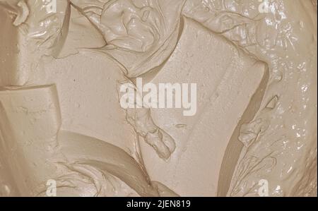 Wet mortar cement paste mixed with masonry trowel in bucket, closeup detail from above Stock Photo