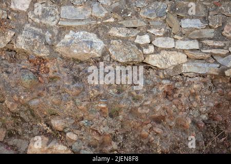Stonewall was built at different times. A stone wall was rebuilt on the old wall. Stock Photo