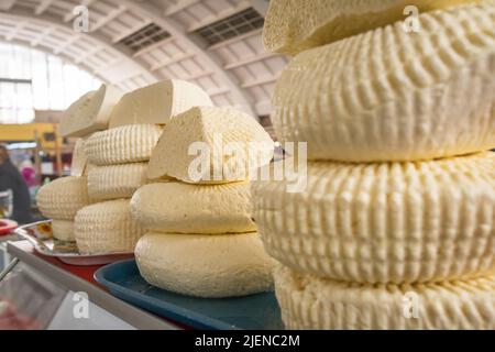 Closeup of piles of round homemade traditional cheese in the market in Georgia Stock Photo